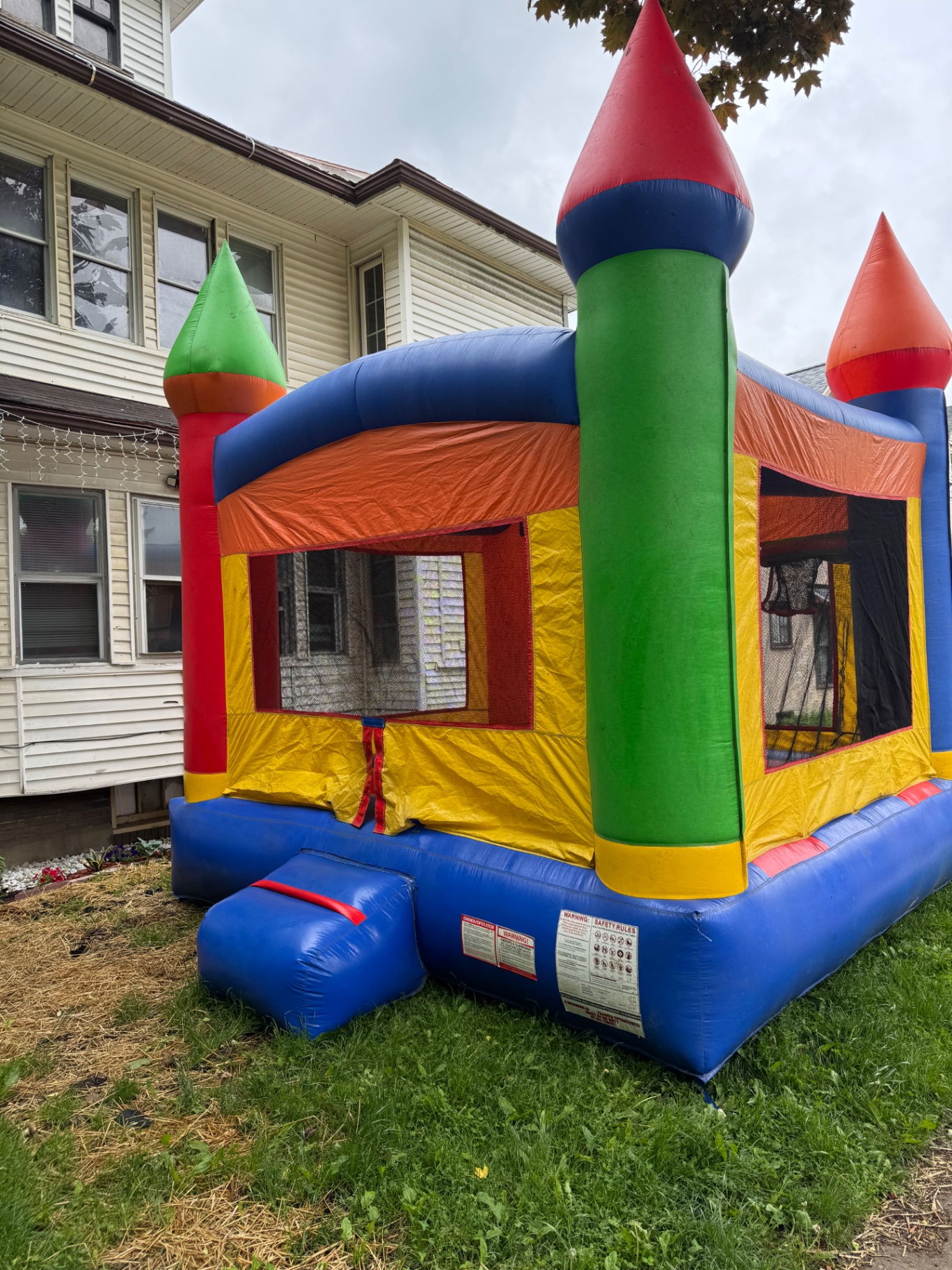 Classic multi-color castle bounce house with red and green turrets